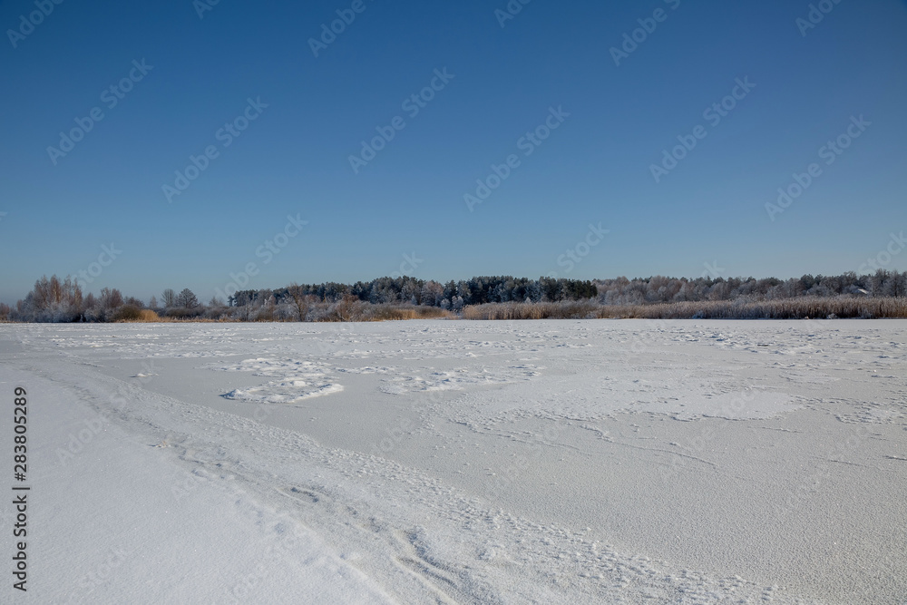 winter landscape with lake and blue sky