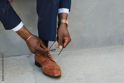 Hands tying shoe lace on man's oxford shoe