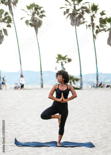 Profile of woman doing yoga pose on beach