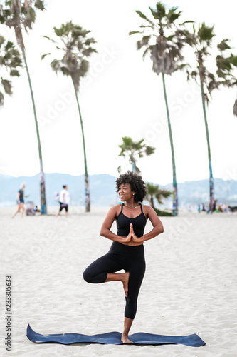 Profile of smiling woman doing yoga on beach
