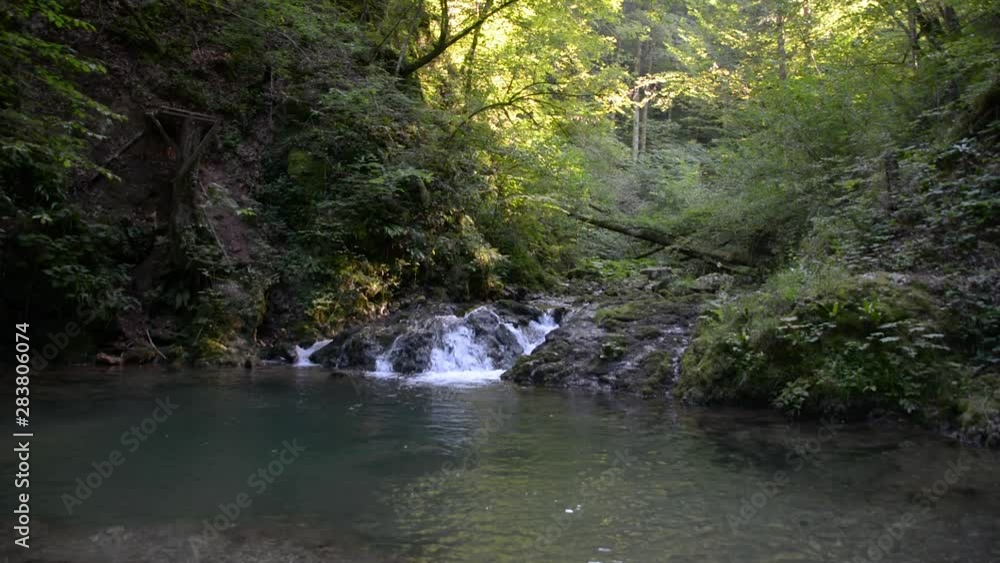 Scenic natural view of waterfall in woods with small pond in foreground Scenic natural view of waterfall in woods with small pond in foreground