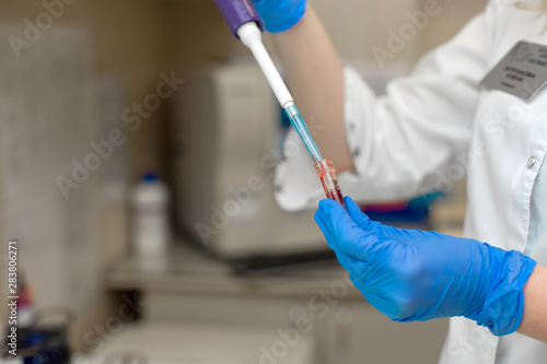 Woman lab technician take blood sample from test tube