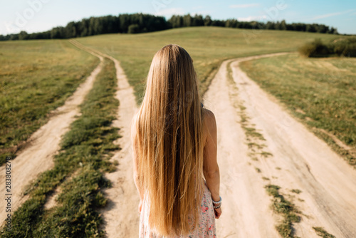 woman in front of two roads thinking deciding hoping for best taking chance