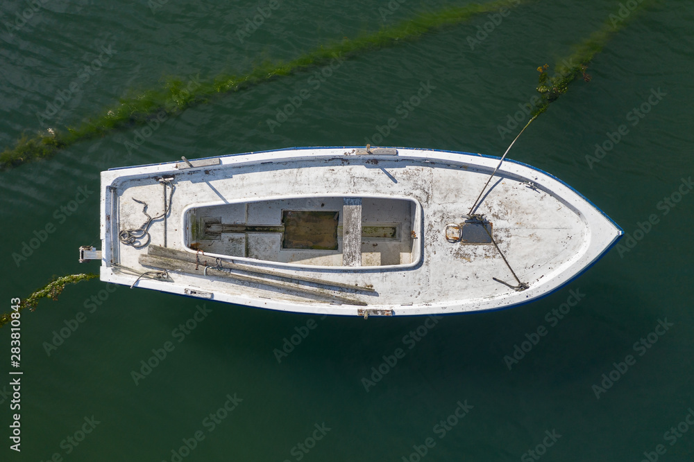 white wooden fishing boat anchored, top view