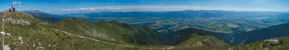 Panoramic view from Baranec peak on Western Tatra mountains or Rohace panorama. Sharp green mountains - ostry rohac, placlive and volovec with hiking trail on ridge. Summer blue sky white clouds.