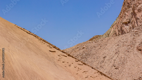 desert rocky sand stone hills frame and blue sky background wallpaper pattern dry scenic landscape with empty space for copy or text 