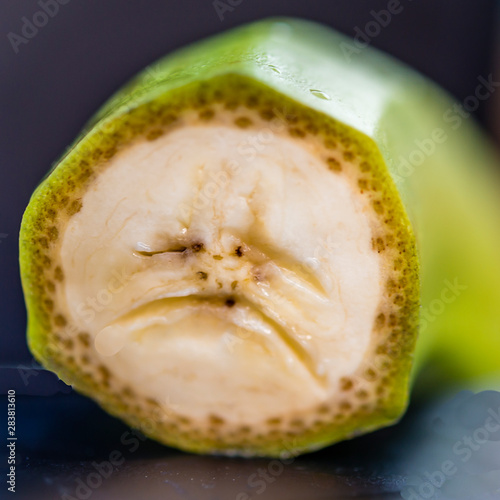 Close-up of Cross section of banana that looks like an unhappy or sad face. A macro example of pareidolia photo