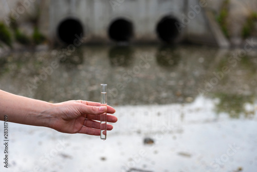 Checking the quality of water in wastewater. Test tube with a sample in hand. Sewage treatment