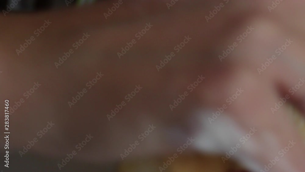 A woman sprinkles flour on rolled dough on the surface of the table. Close-up shot. A woman sprinkles flour on rolled dough on the surface of the table. Close-up shot.