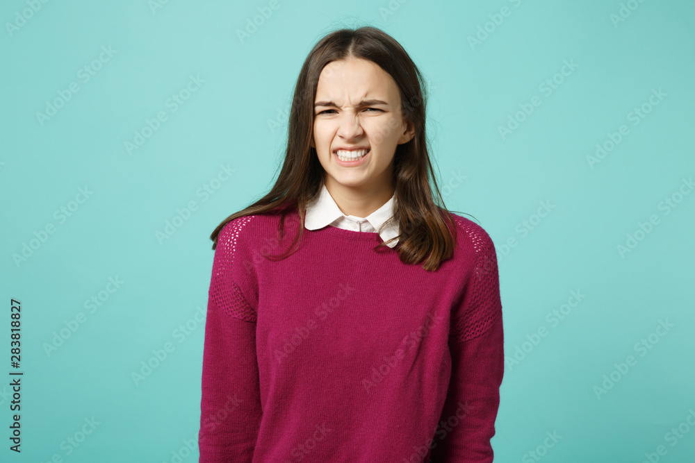 Fototapeta premium Young fun sad upset perplexed disturb brunette woman girl in red casual clothes posing isolated on blue wall background studio portrait. People sincere emotions lifestyle concept. Mock up copy space.