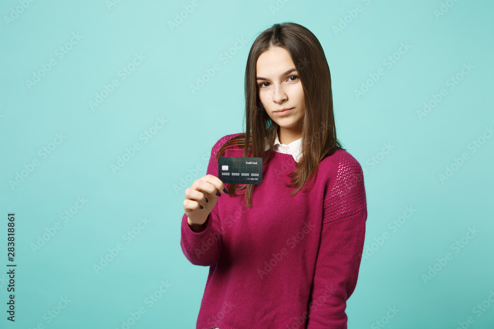 Young brunette woman girl in casual clothes posing isolated on blue turquoise background studio portrait. People sincere emotions lifestyle concept. Mock up copy space. Hold in hand credit bank card. Young brunette woman girl in casual clothes posing isolated on blue turquoise background studio portrait. People sincere emotions lifestyle concept. Mock up copy space. Hold in hand credit bank card.