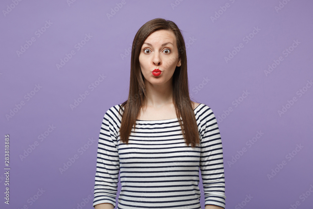 Pretty funny young brunette woman girl in casual striped clothes posing isolated on violet purple background studio portrait. People lifestyle concept. Mock up copy space. Looking camera blowing lips. Pretty funny young brunette woman girl in casual striped clothes posing isolated on violet purple background studio portrait. People lifestyle concept. Mock up copy space. Looking camera blowing lips.