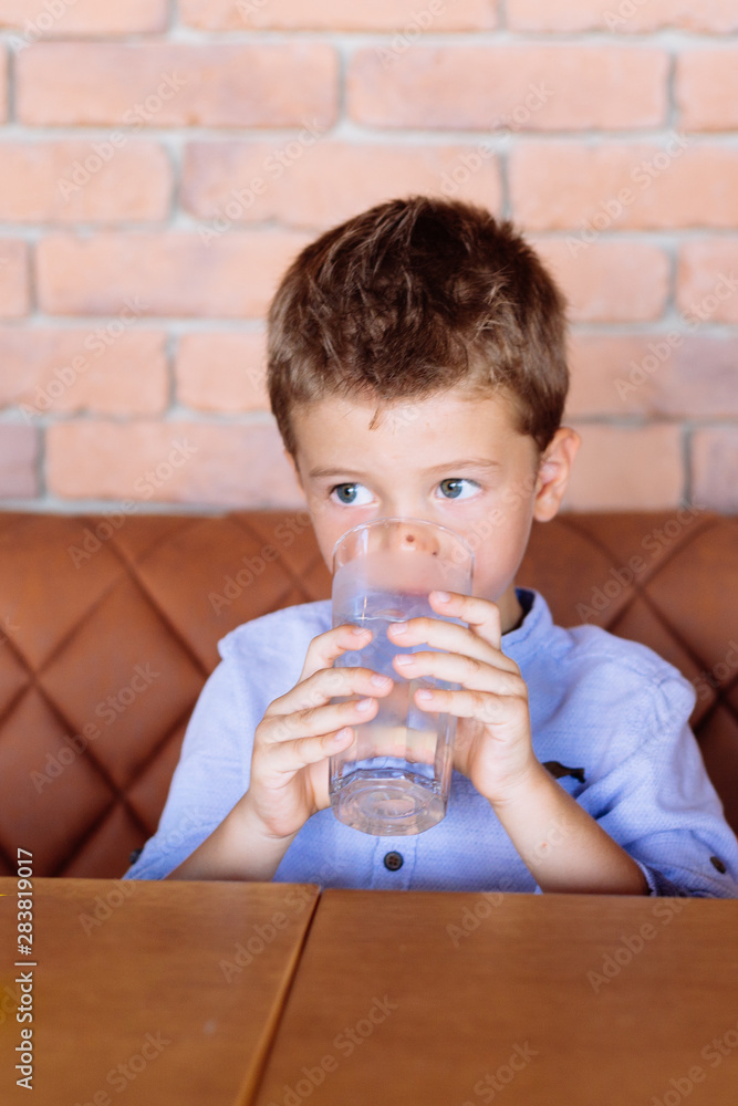 Boy drinking cold water from the glass. Children health care concept Boy drinking cold water from the glass. Children health care concept