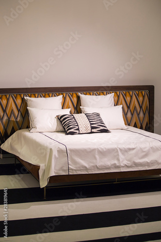 Modern stylish bedroom, double bed with headrest in the Art Nouveau style, retro, with a zigzag pattern, loft bedroom