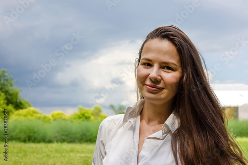 фотографія young white long dark haired woman lady in a white blouse  portrait with a copy