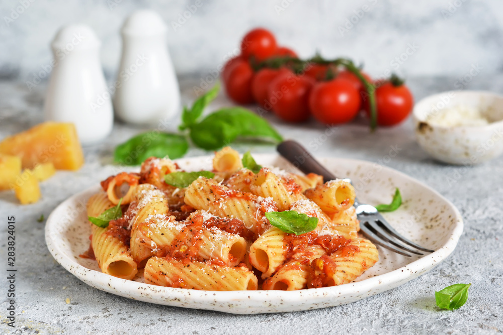 Pasta with tomato sauce and basil. Pasta tartilloni on a dark background. Pasta with tomato sauce and basil. Pasta tartilloni on a dark background.
