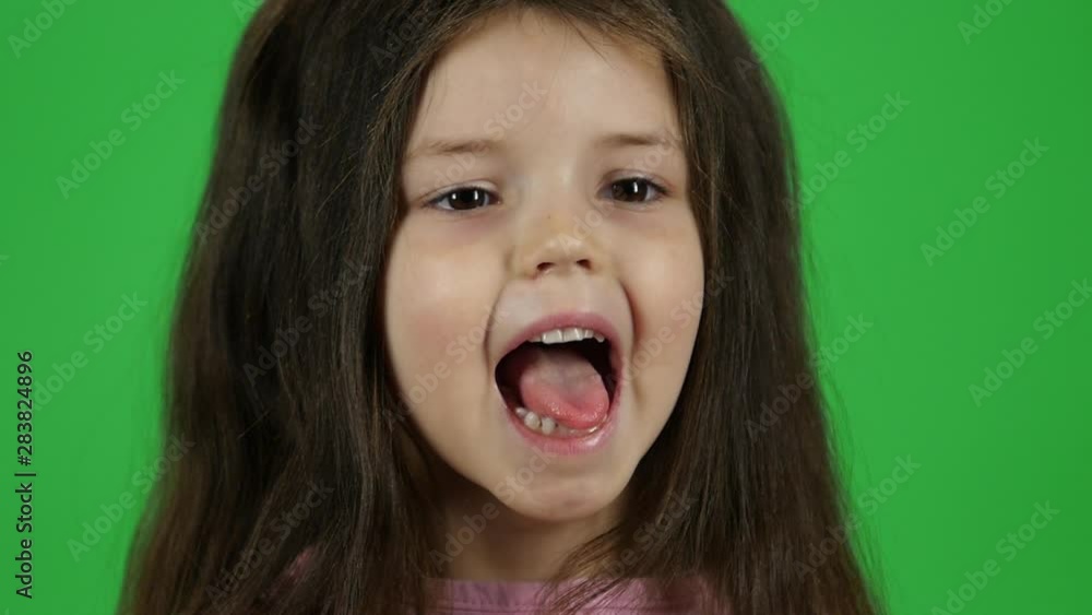 Cute baby screaming with smile on green screen in the studio. Slow motion. Close up Cute baby screaming with smile on green screen in the studio. Slow motion. Close up