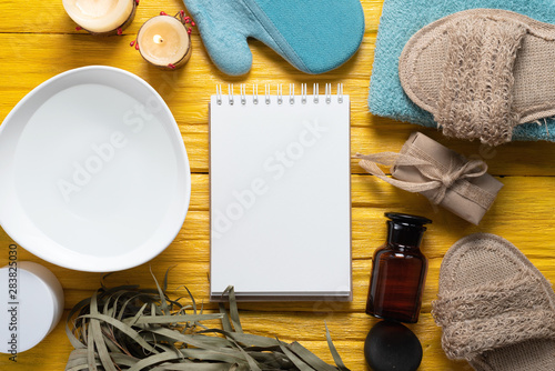 Spa blank page notepad with a copy space mockup. Bath accessories on a yellow wooden floor background.