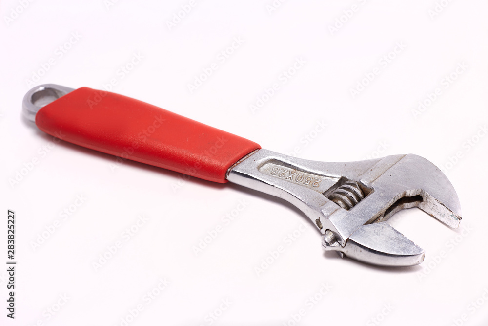 Adjustable wrench with red rubberized handle, isolated on white background Adjustable wrench with red rubberized handle, isolated on white background