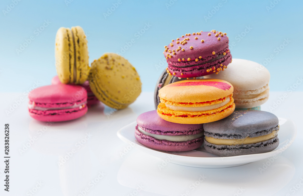 Stack of macaroons, French cookies on a white saucer. Holiday time concept Stack of macaroons, French cookies on a white saucer. Holiday time concept