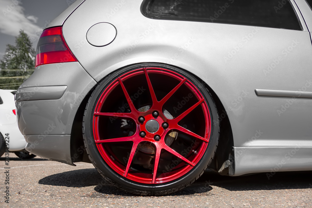 red candy colored light alloy wheels on silver hatchback Stock-Foto | Adobe  Stock