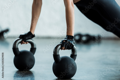 cropped view of young woman exercising with dumbbells
