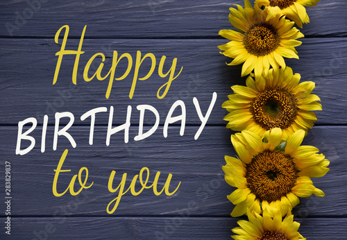 Happy Birthday to You. Birthday greeting card with flowers on a wooden background. Greeting card for girls, congratulations on mother's day. View from above