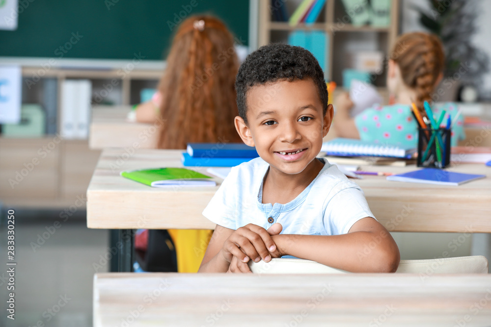 Cute little African-American boy during lesson in classroom Cute little African-American boy during lesson in classroom