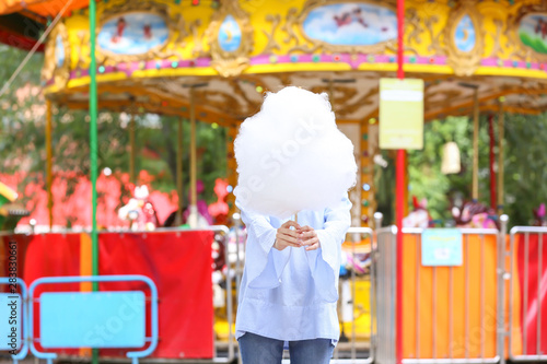 Woman with sweet cotton candy in amusement park © Pixel-Shot