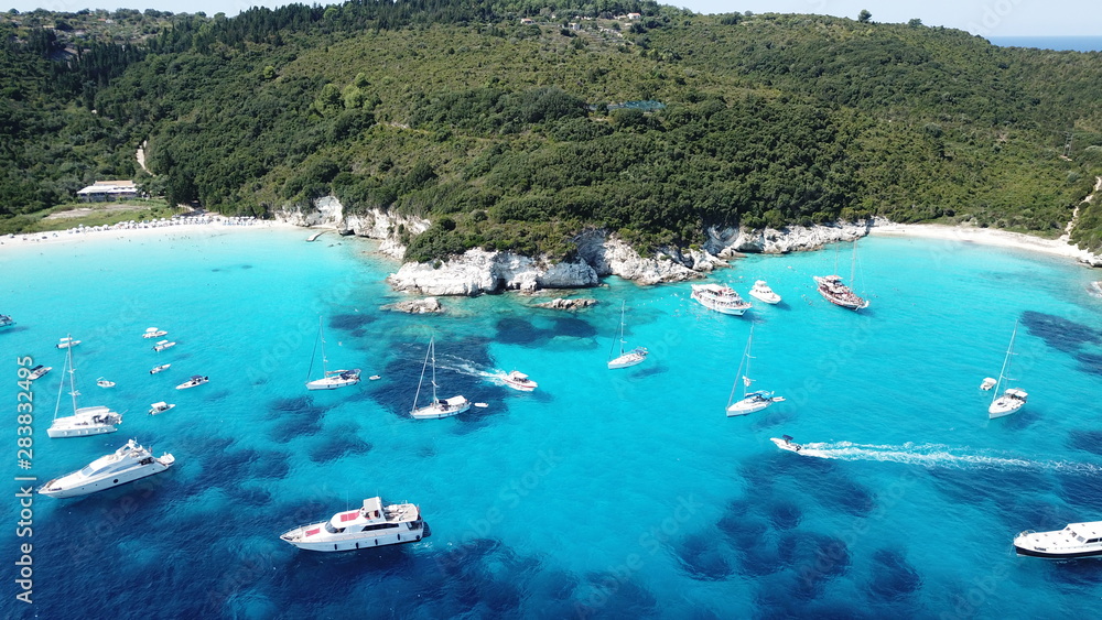 Obraz premium Aerial drone photo of tropical paradise turquoise beach of Voutoumi with sail boats docked in island of Antipaxos, Ionian, Greece
