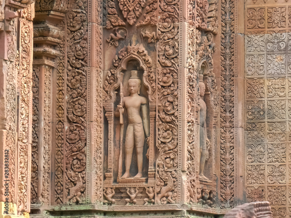 a bas relief carving of a devata at banteay srei in angkor