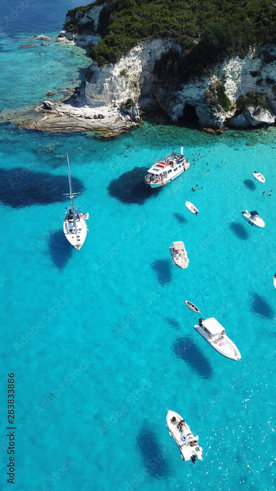 Obraz premium Aerial drone photo of beautiful exotic paradise turquoise sandy beach of Voutoumi with sail boats docked in island of Anti paxos, Ionian, Greece