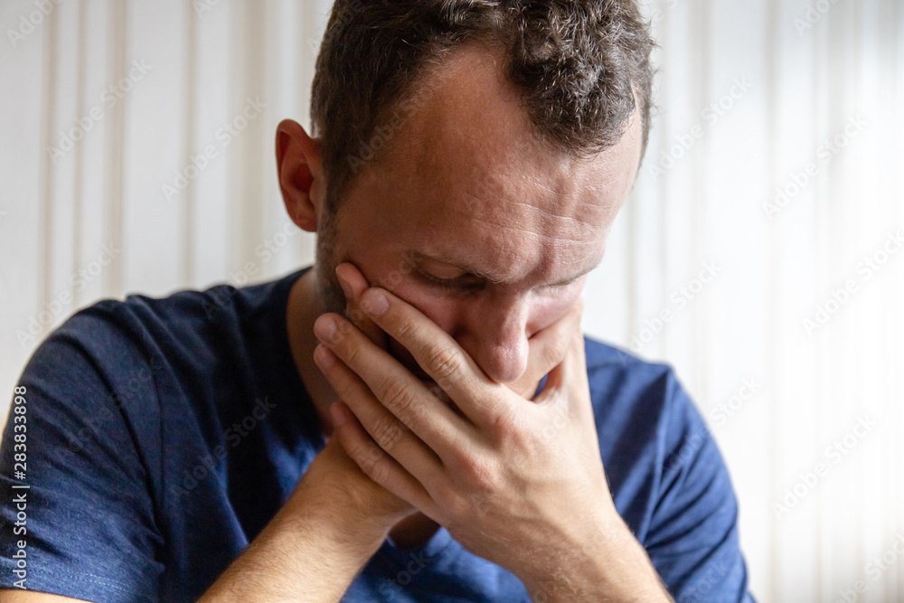 sad young man holding his head from grief and worries sad young man holding his head from grief and worries