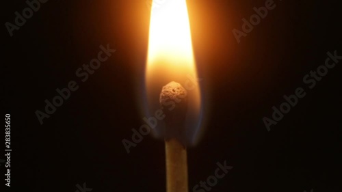 a match igniting, burning then going off on a black background closeup shot 