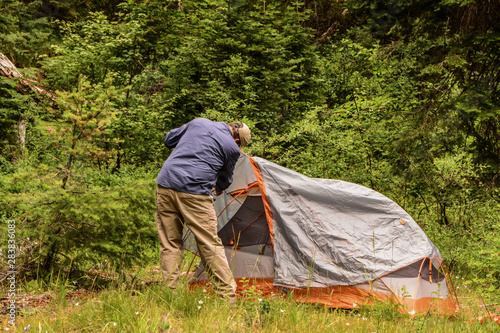 backpacker setting up camp tent