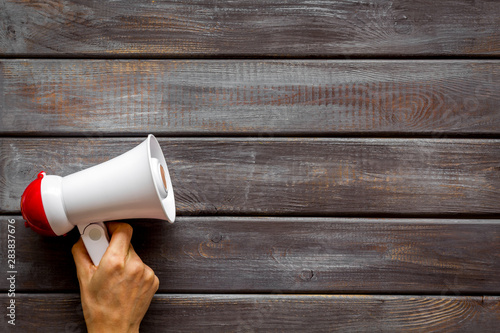 Announcement with megaphone in hand on wooden background top view mockup