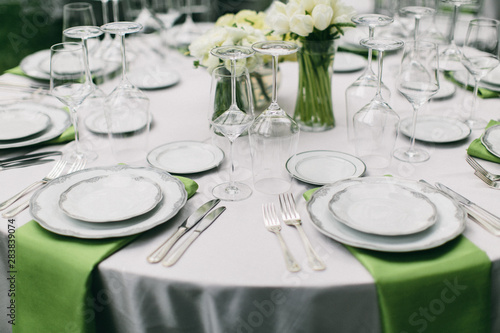 Valokuvatapetti wedding reception table setting, fine china plates, green napkin hanging off tab