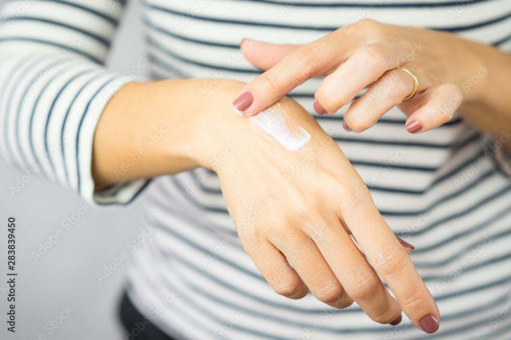 Φωτογραφία A woman applying scar removal cream to healed the cooking oil burn scar on a her hands