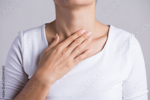 Sore Throat. Closeup Of Beautiful Young Woman Hand Touching Her Ill Neck. Healthcare and medical concept.