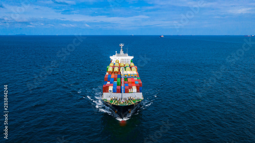 Container cargo ship carrying container for business freight import and export, Aerial view container ship arriving in commercial port. © Kalyakan