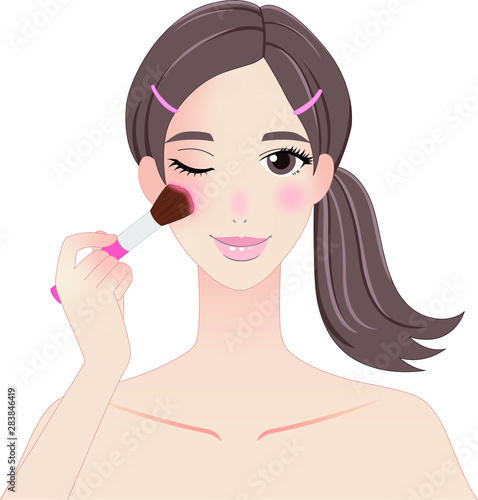チークを塗ってメイクアップする女性