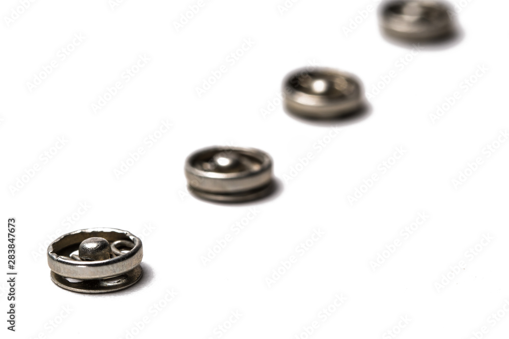 Close up of a group of metal Snap on Buttons on white background. Close up of a group of metal Snap on Buttons on white background.