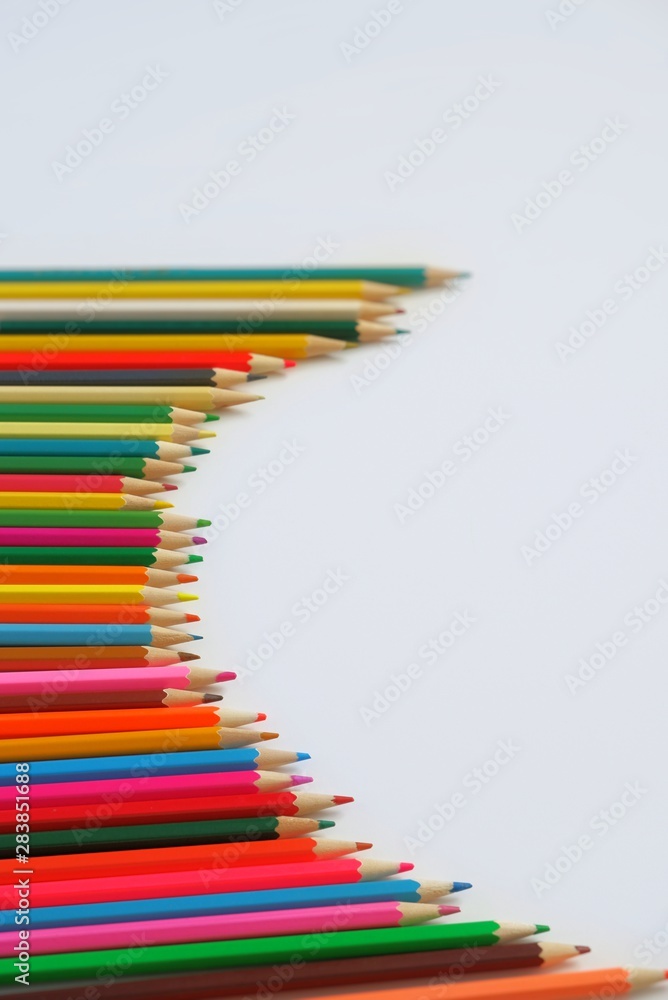 Composition semicircle made of mixed colored pencils on a white background.The concept of anti-stress, hobby.With selective focus,copy space for text. Composition semicircle made of mixed colored pencils on a white background.The concept of anti-stress, hobby.With selective focus,copy space for text.