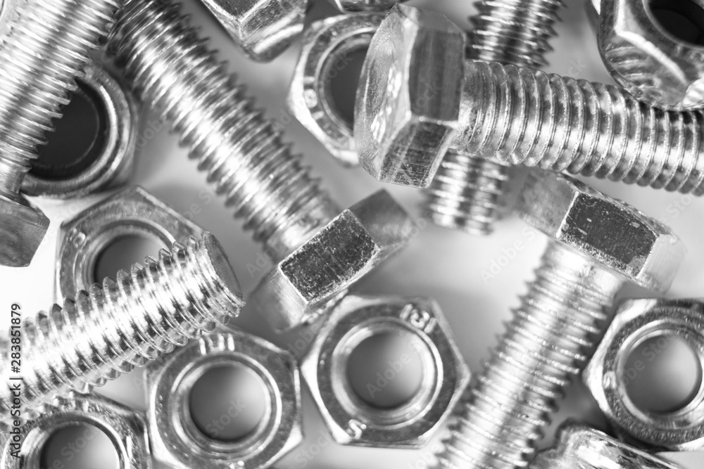 Metal bolts and nuts in a row background. Chromed screw bolts and nuts