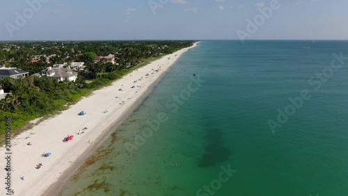 Drone aerial of shoreline with people enjoying the sunny day photo