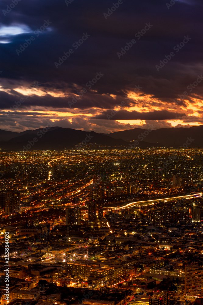 Fototapeta premium the city lights in a cloudy sunset before the rain