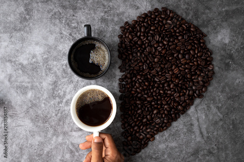 concept of black coffee lover, hand hold a cup of coffee, view from above table. photo