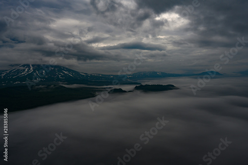 Panoramic view of the city Petropavlovsk-Kamchatsky and volcanoes: Koryaksky Volcano, Avacha Volcano, Kozelsky Volcano. Russian Far East, Kamchatka Peninsula.