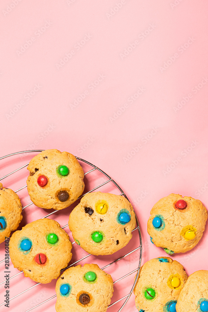 Homemade cookies decorated with colorful jelly beans candies a pink background. Top view flat layout. Holiday concept.