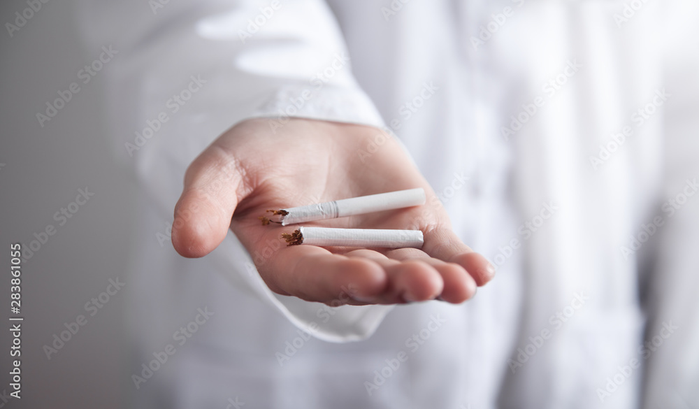 Doctor holding broken cigarette. Stop smoking Doctor holding broken cigarette. Stop smoking